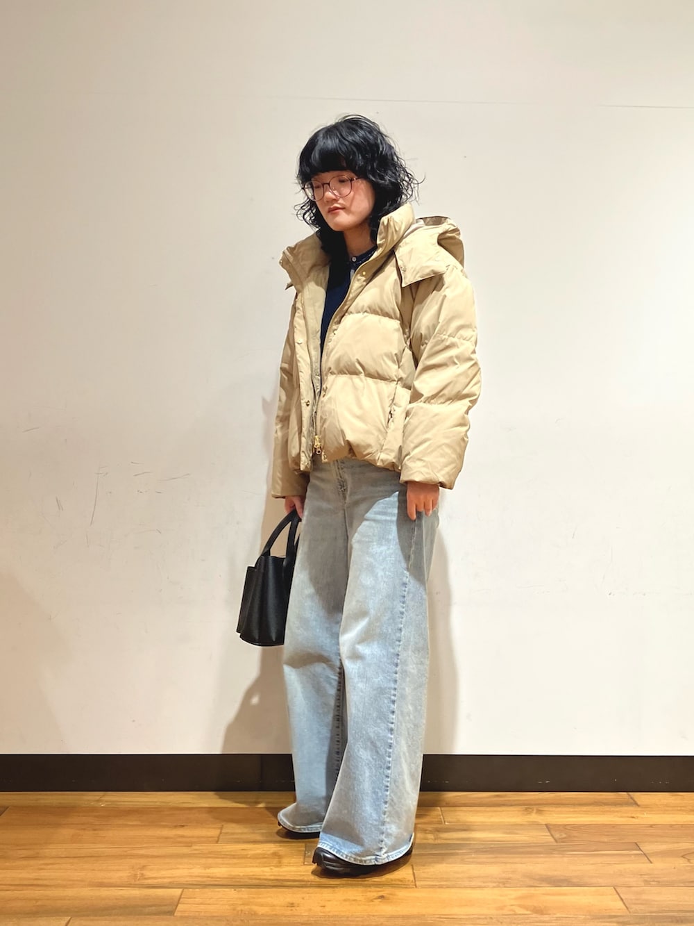 ブラック系のスニーカー、パープル系のダウンジャケット/コート、ブルー系のカーディガン/ボレロを着用したレディースの冬コーディネートの2枚目の写真