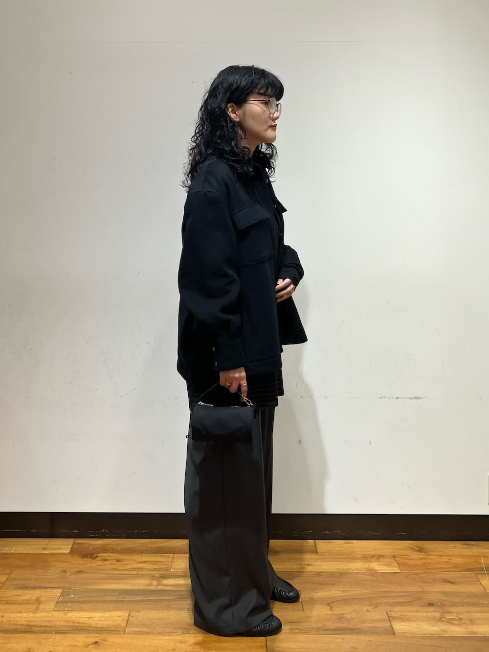 ブラック系のシャツ/ブラウス、グレー系のその他パンツ、ブラック系のハンドバッグを着用したレディースの秋コーディネートの3枚目の写真