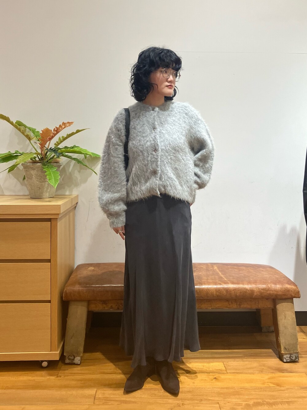 グレー系のスカート、グレー系のカーディガン/ボレロ、ブラック系のショルダーバッグを着用したレディースの秋コーディネートの3枚目の写真