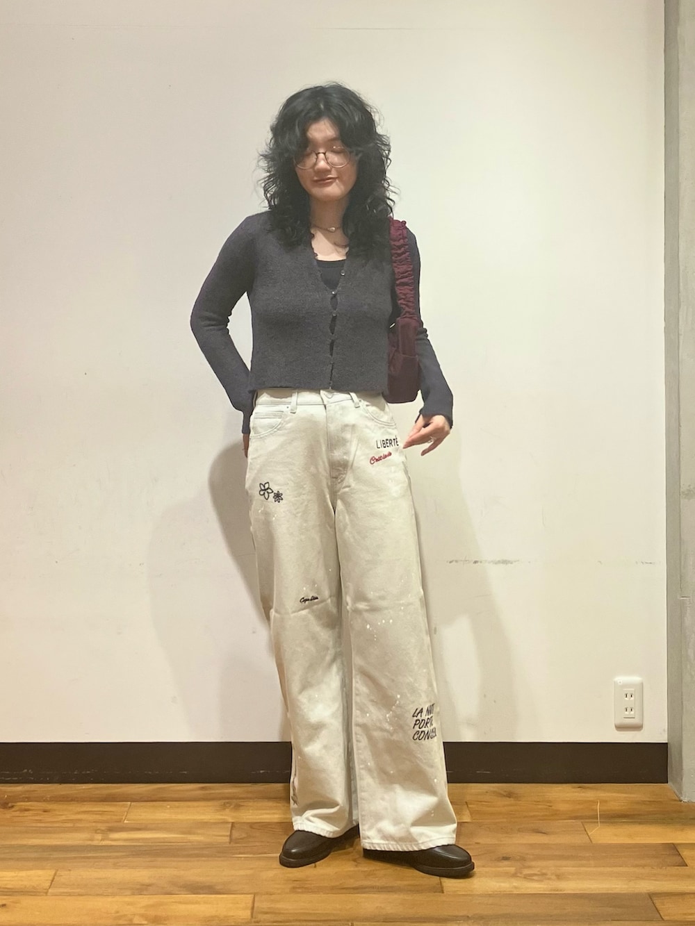 グレー系のデニムパンツ、ブラック系のローファー、グレー系のカーディガン/ボレロを着用したレディースの夏コーディネートの2枚目の写真