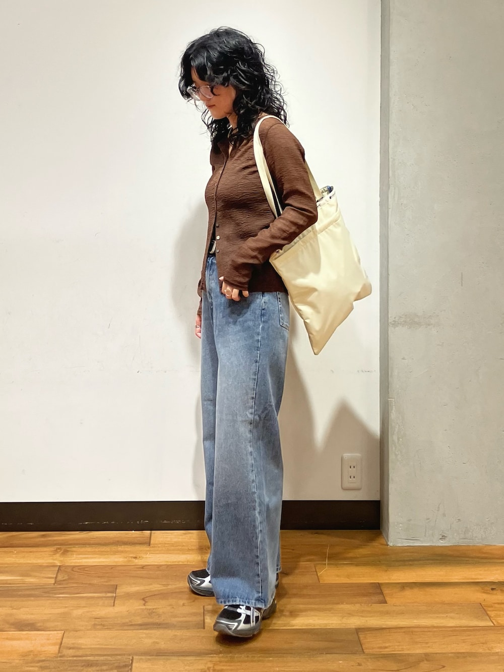ブラウン系のカーディガン/ボレロ、ブルー系のデニムパンツ、ベージュ系のトートバッグを着用したレディースの夏コーディネートの3枚目の写真