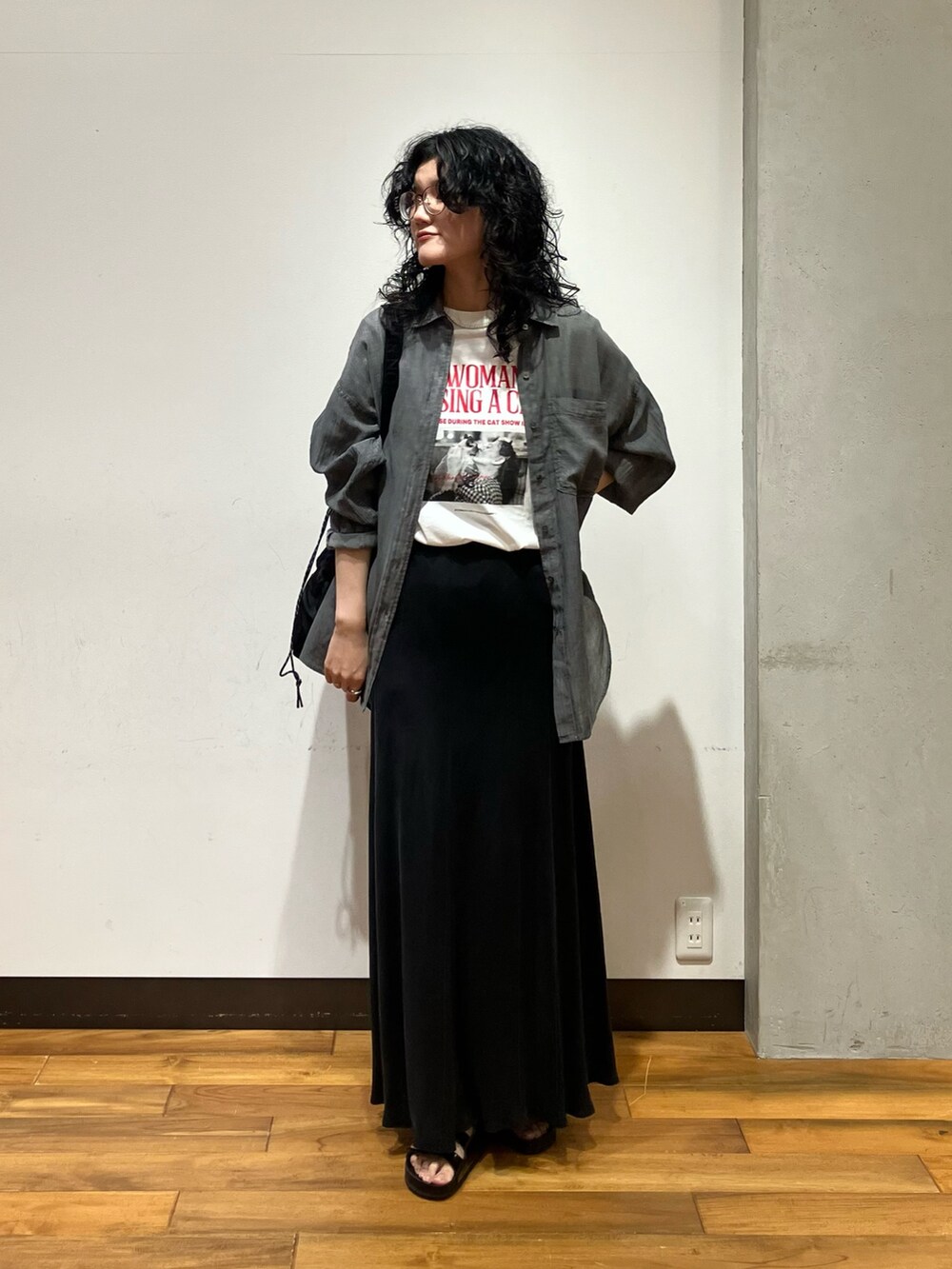 ブラック系のショルダーバッグ、グレー系のシャツ/ブラウス、ホワイト系のTシャツ/カットソーを着用したレディースの夏コーディネートの2枚目の写真