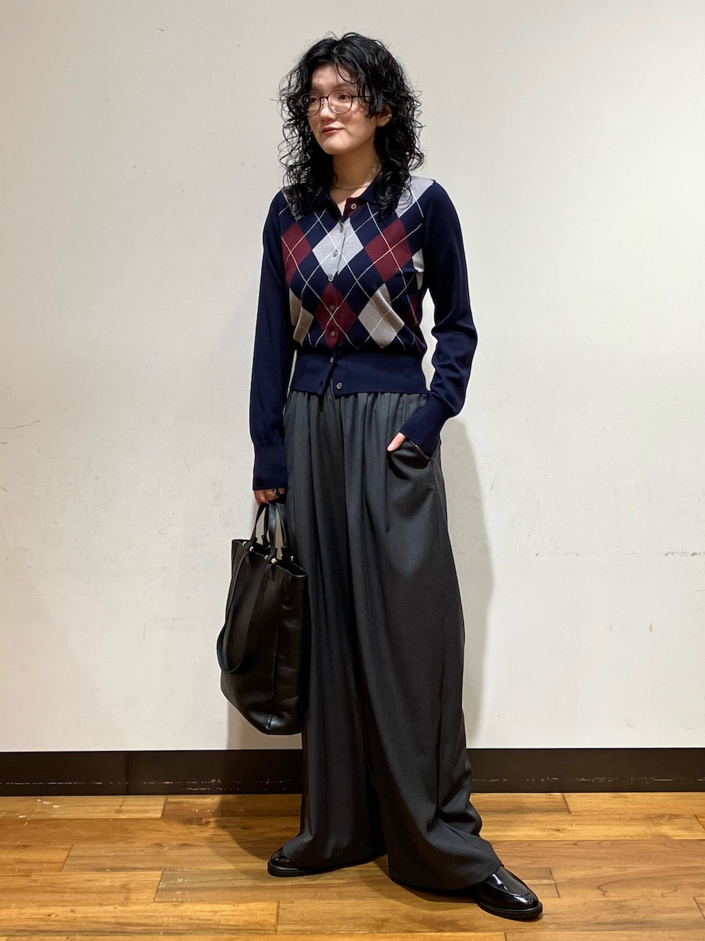 グレー系のその他パンツ、ブルー系のカーディガン/ボレロ、ブラック系のローファーを着用したレディースの秋コーディネートの2枚目の写真