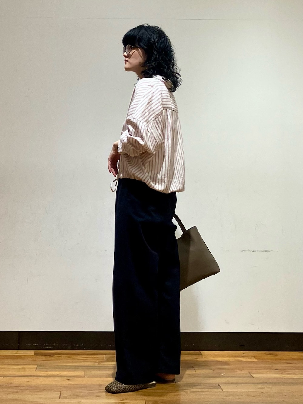 ブルー系のその他パンツ、グレー系のトートバッグ、ブラウン系のサンダルを着用したレディースの春コーディネートの2枚目の写真