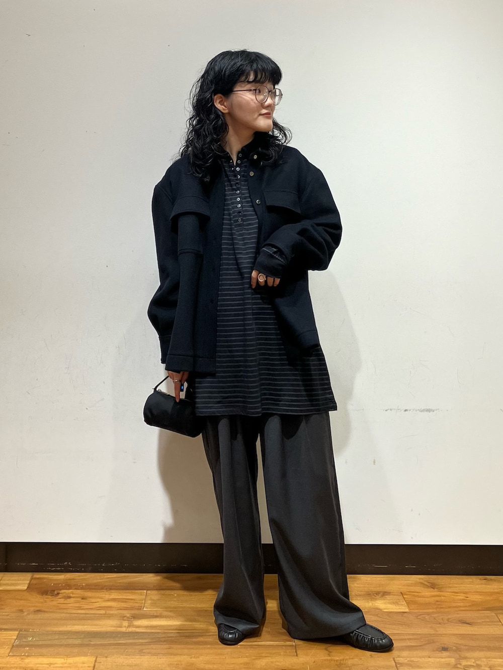 ブラック系のシャツ/ブラウス、グレー系のその他パンツ、ブラック系のハンドバッグを着用したレディースの秋コーディネートの2枚目の写真