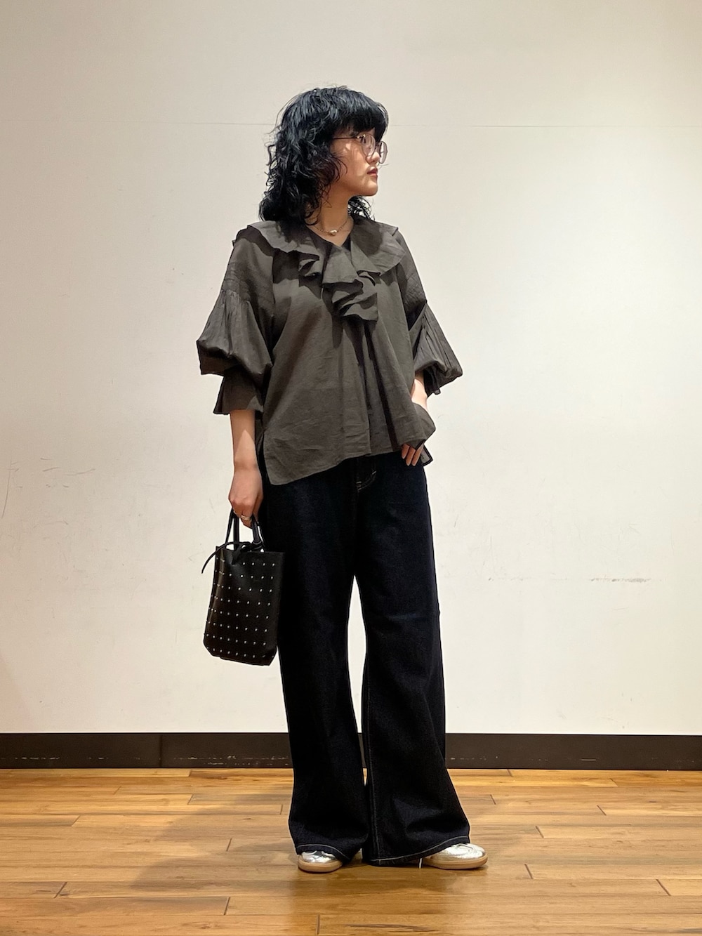 シルバー系のスニーカー、ブルー系のデニムパンツ、ブラウン系のシャツ/ブラウスを着用したレディースの春コーディネートの3枚目の写真