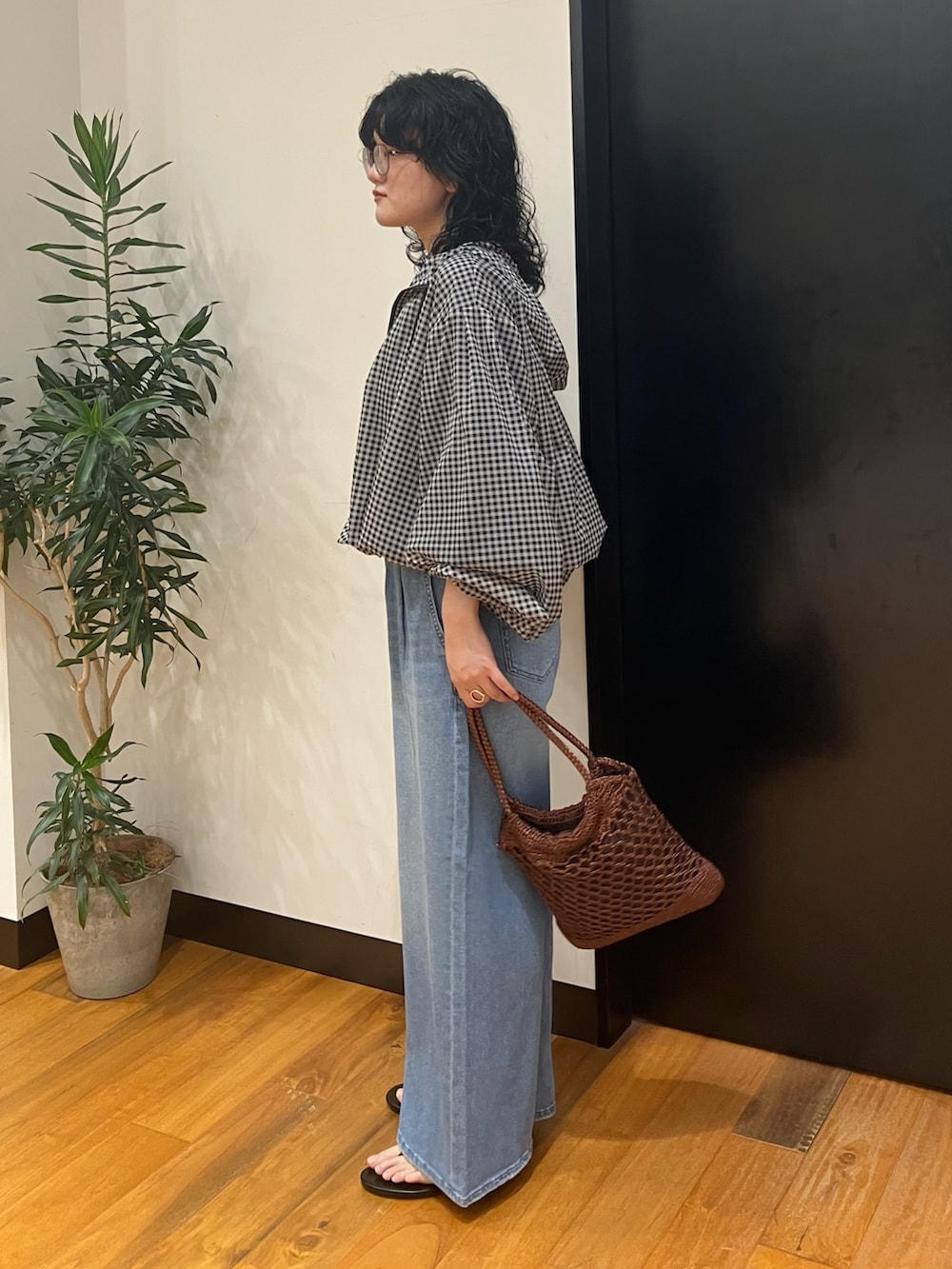 ブラウン系のトートバッグ、ブルー系のデニムパンツ、その他のブルゾンを着用したレディースの春コーディネートの2枚目の写真