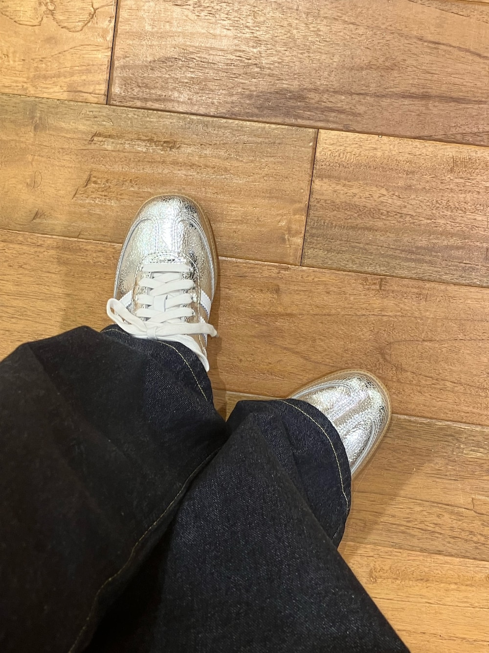 シルバー系のスニーカー、ブルー系のデニムパンツ、ブラウン系のシャツ/ブラウスを着用したレディースの春コーディネートの4枚目の写真