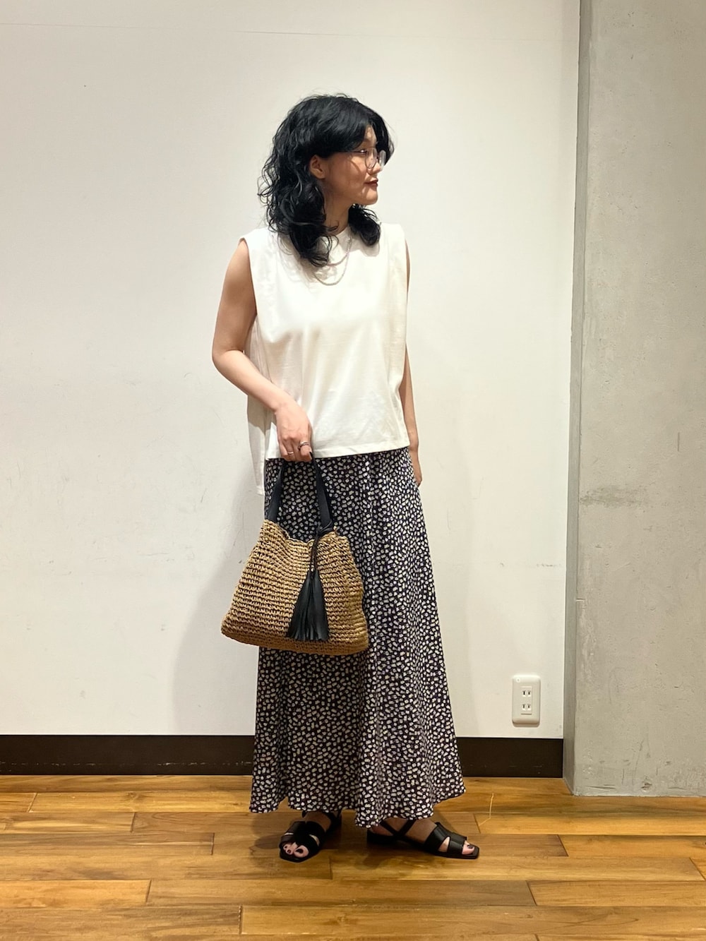 ホワイト系のスカート、ホワイト系のタンクトップ、イエロー系のかごバッグを着用したレディースの夏コーディネートの2枚目の写真