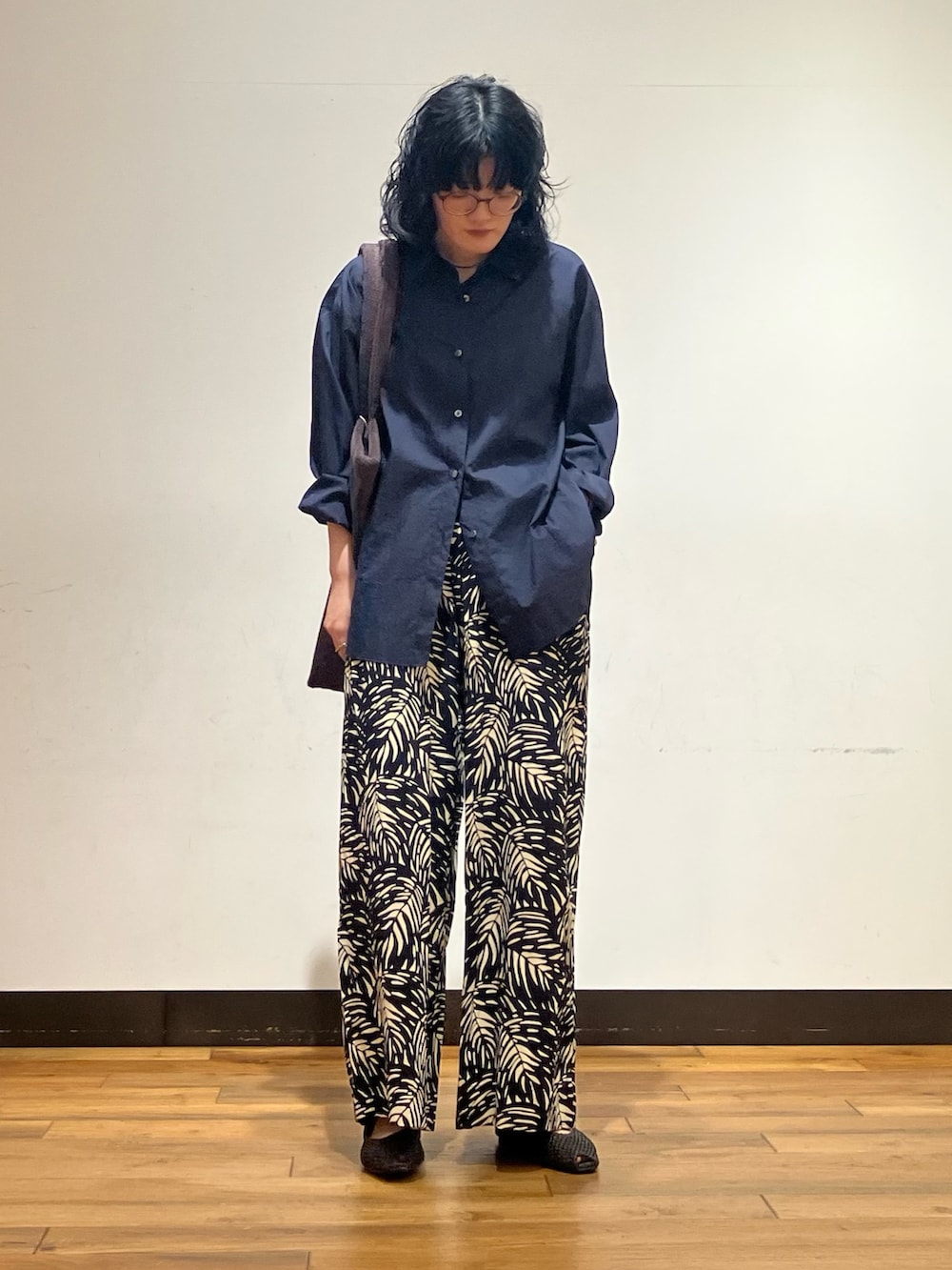 ブルー系のシャツ/ブラウス、ブラウン系のトートバッグ、ブラック系のその他シューズを着用したレディースの春コーディネートの3枚目の写真