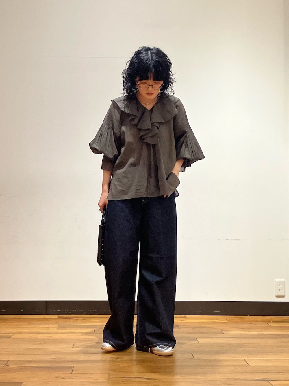 シルバー系のスニーカー、ブルー系のデニムパンツ、ブラウン系のシャツ/ブラウスを着用したレディースの春コーディネートの2枚目の写真