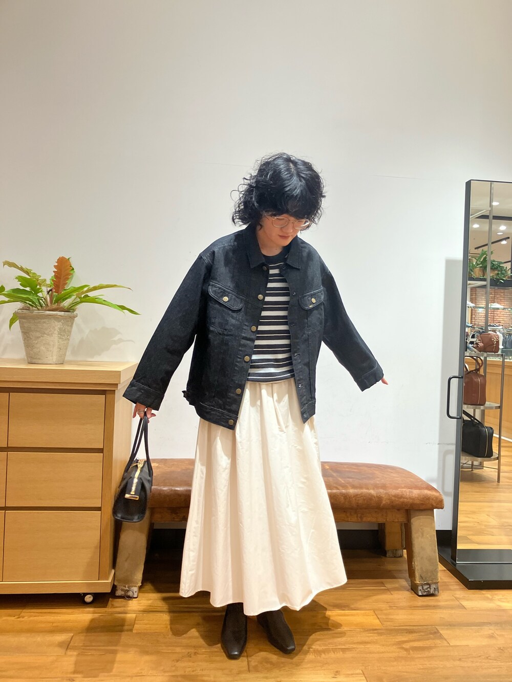 グレー系のニット/セーター、ホワイト系のスカート、ブラック系のローファーを着用したレディースの秋コーディネートの3枚目の写真