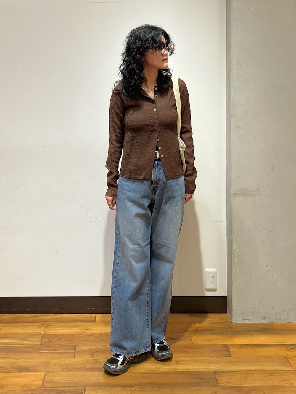 ブラウン系のカーディガン/ボレロ、ブルー系のデニムパンツ、ベージュ系のトートバッグを着用したレディースの夏コーディネートの2枚目の写真