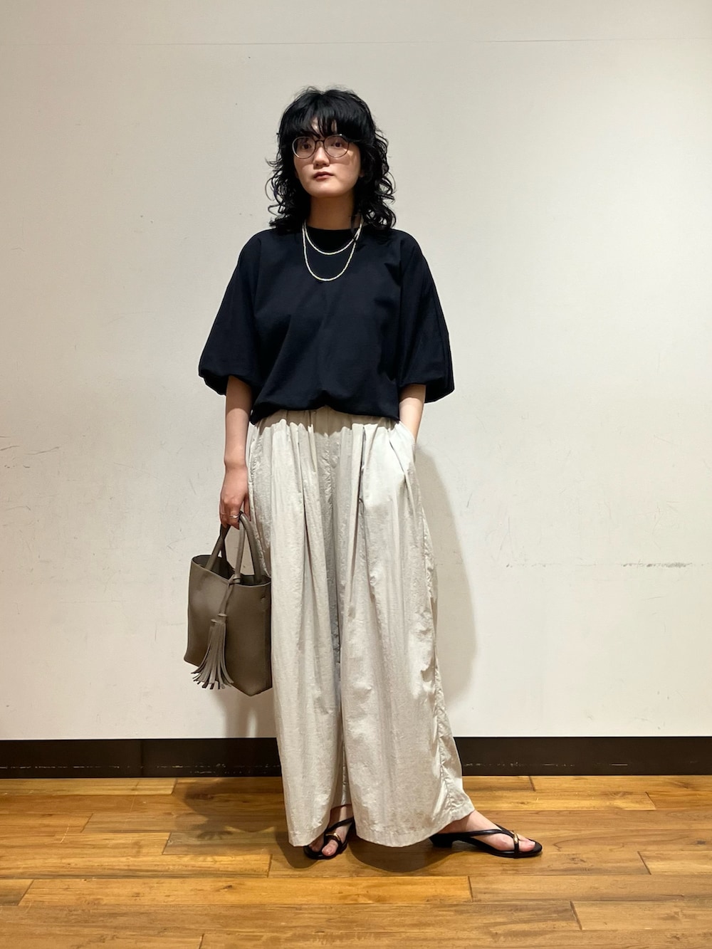 グレー系のその他パンツ、ブラック系のサンダル、グレー系のトートバッグを着用したレディースの春コーディネートの3枚目の写真