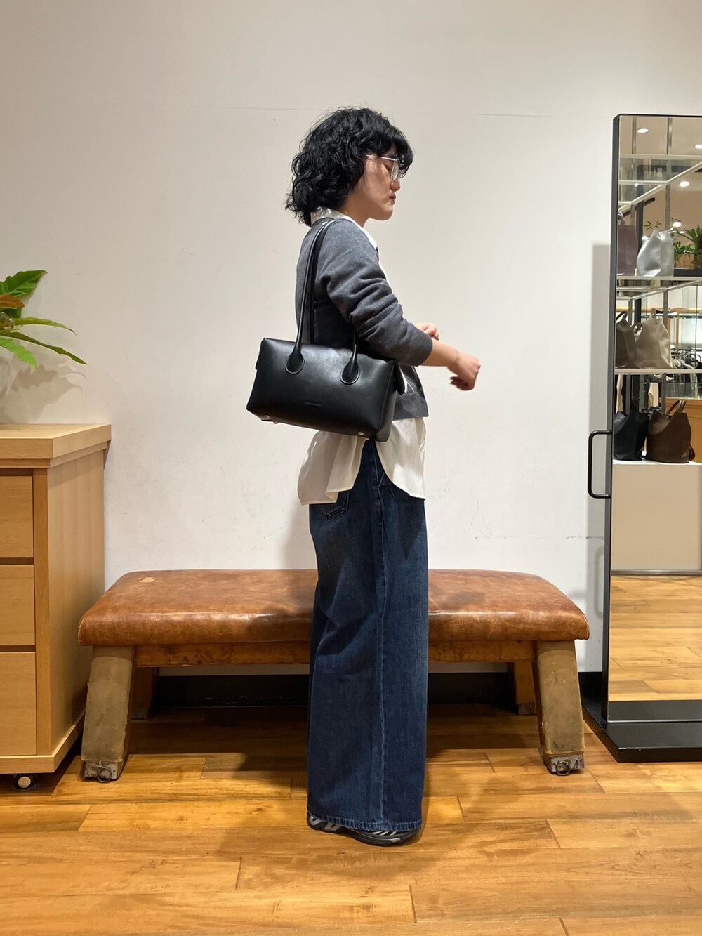 ホワイト系のシャツ/ブラウス、グレー系のニット/セーター、ブルー系のデニムパンツを着用したレディースの秋コーディネートの4枚目の写真