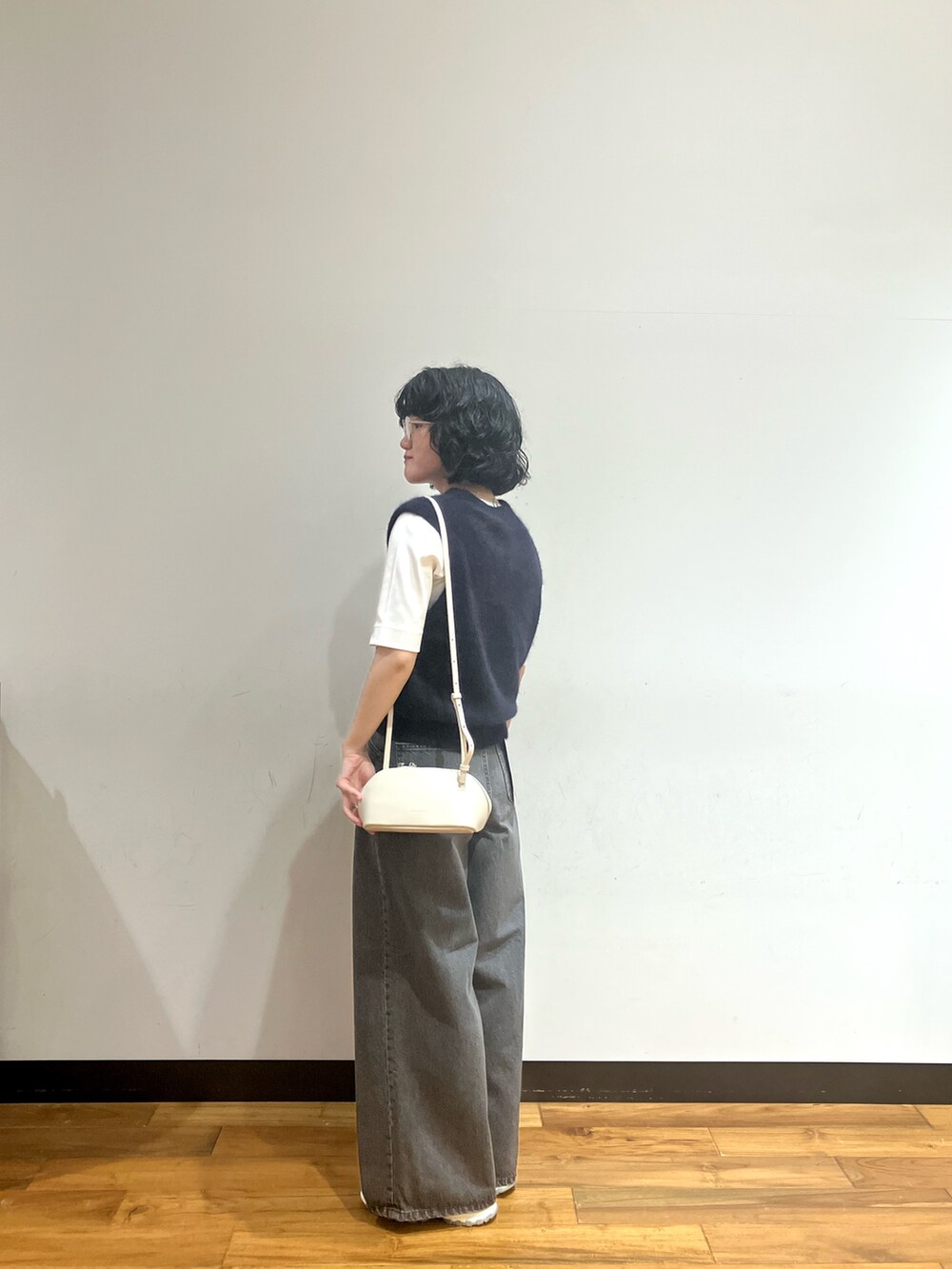 ホワイト系のスニーカー、ブラック系のデニムパンツ、ホワイト系のTシャツ/カットソーを着用したレディースの秋コーディネートの2枚目の写真