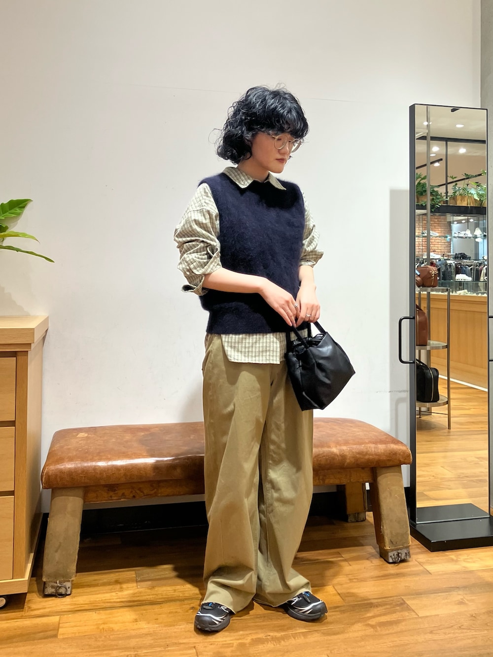 ブラック系のショルダーバッグ、ブラック系のスニーカー、グリーン系のシャツ/ブラウスを着用したレディースの秋コーディネートの2枚目の写真