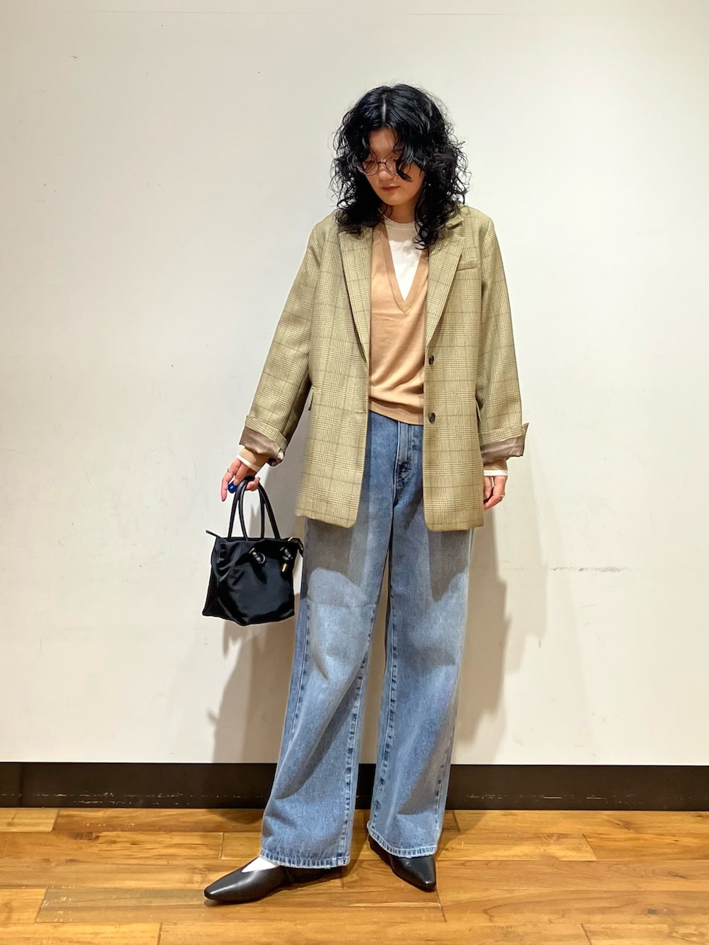 ブラック系のその他シューズ、ブルー系のデニムパンツ、ベージュ系のニット/セーターを着用したレディースの秋コーディネートの3枚目の写真