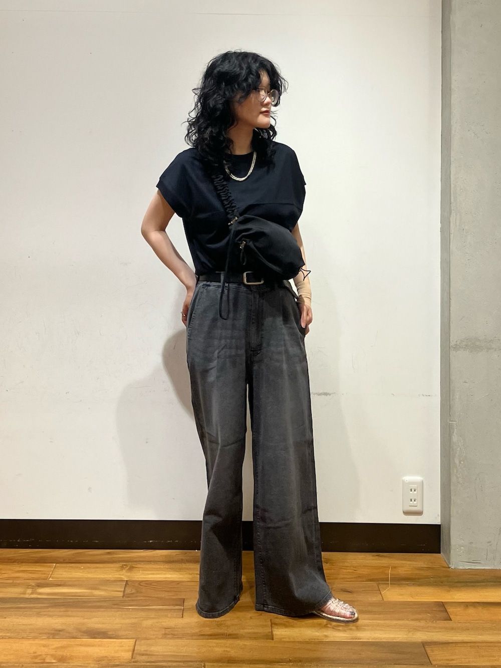 ブラック系のデニムパンツ、その他のサンダル、ブラック系のショルダーバッグを着用したレディースの夏コーディネートの4枚目の写真