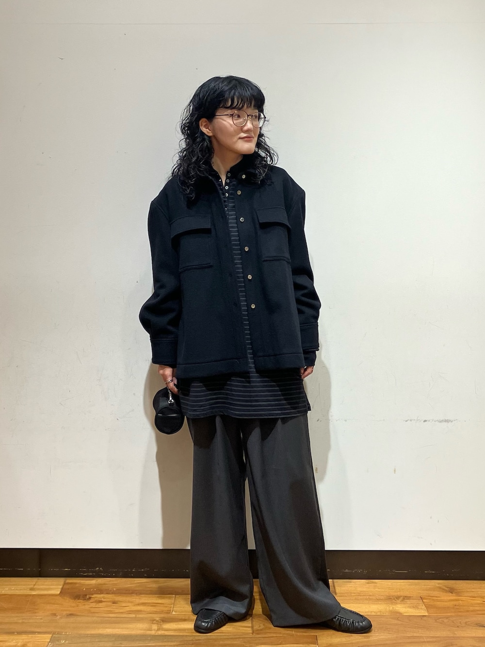 ブラック系のシャツ/ブラウス、グレー系のその他パンツ、ブラック系のハンドバッグを着用したレディースの秋コーディネートの4枚目の写真
