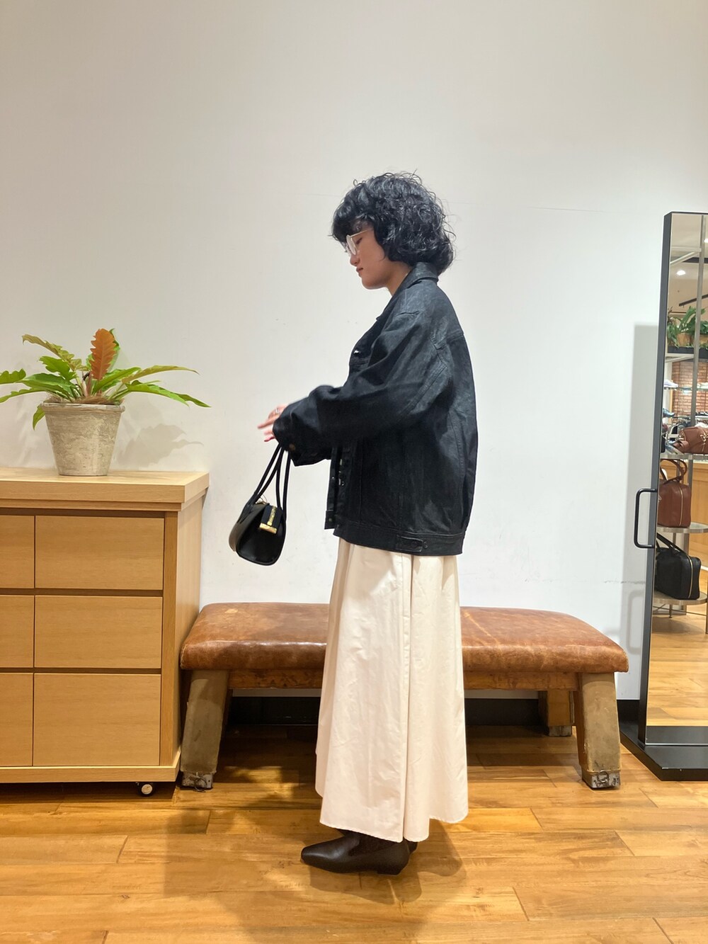 グレー系のニット/セーター、ホワイト系のスカート、ブラック系のローファーを着用したレディースの秋コーディネートの2枚目の写真