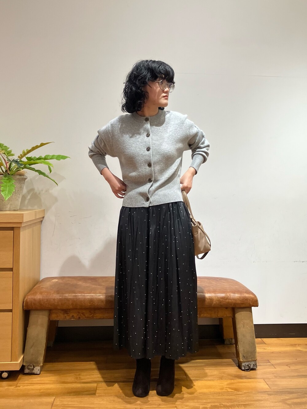グレー系のカーディガン/ボレロ、ブラック系のスカート、ベージュ系のショルダーバッグを着用したレディースの秋コーディネートの4枚目の写真