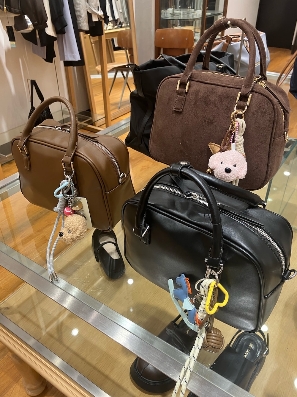 ホワイト系のシャツ/ブラウス、ベージュ系のその他アウター、ブラック系のボストンバッグを着用したレディースの春コーディネートの4枚目の写真