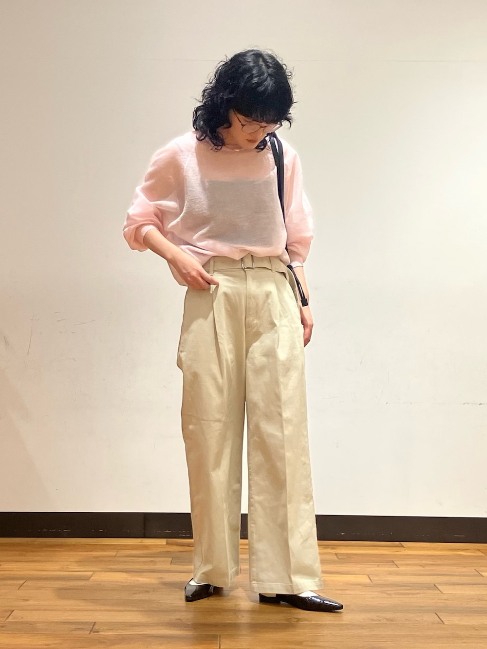 ピンク系のニット/セーター、ベージュ系のその他パンツ、ブラック系のショルダーバッグを着用したレディースの春コーディネートの2枚目の写真