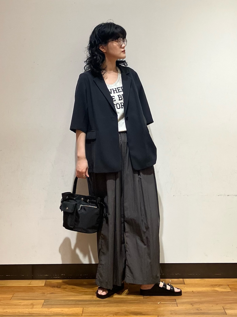 グレー系のその他パンツ、ブラック系のサンダル、ブラック系のトートバッグを着用したレディースの春コーディネートの2枚目の写真