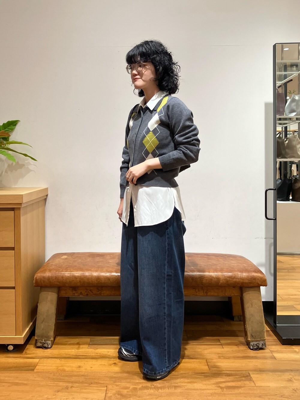 ホワイト系のシャツ/ブラウス、グレー系のニット/セーター、ブルー系のデニムパンツを着用したレディースの秋コーディネートの3枚目の写真