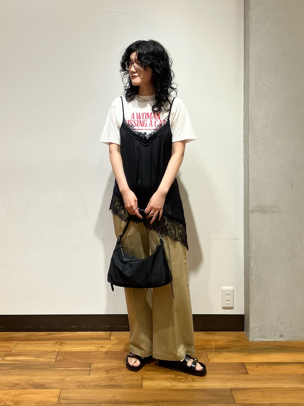 ブラック系のショルダーバッグ、ベージュ系のその他パンツ、ブラック系のキャミソールを着用したレディースの夏コーディネートの2枚目の写真