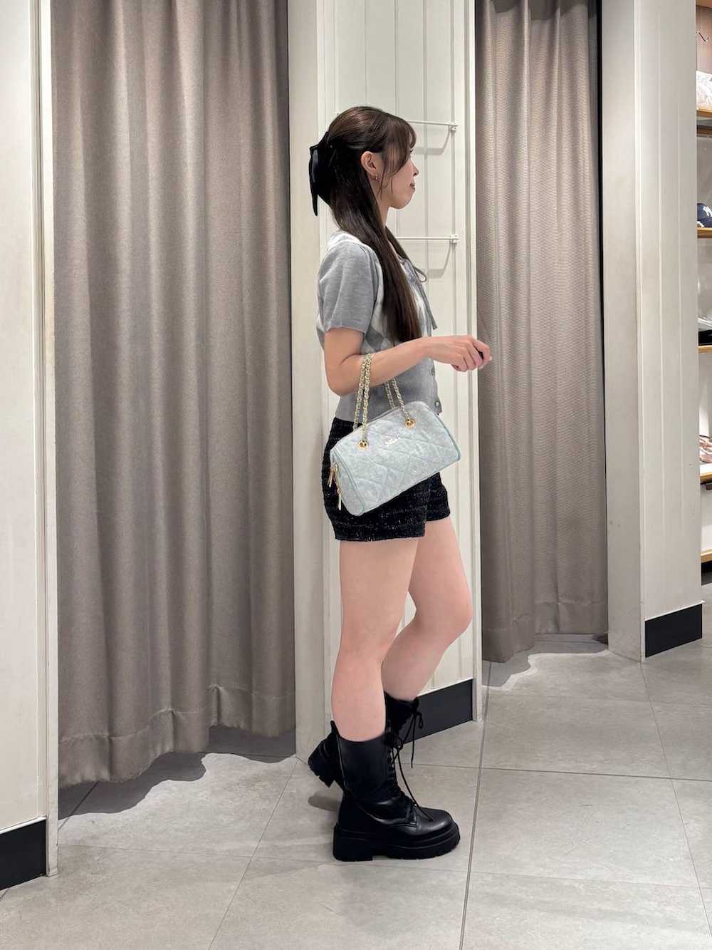 グレー系のニット/セーター、ブルー系のボストンバッグ、ブラック系のその他パンツを着用したレディースの夏コーディネートの2枚目の写真