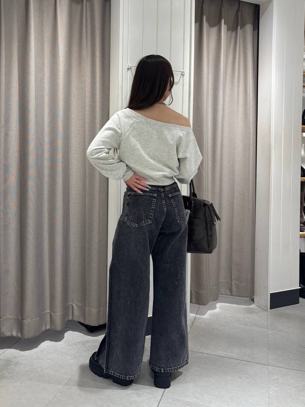 ベージュ系のスウェット、ブラック系のデニムパンツ、ブラウン系のボストンバッグを着用したレディースの冬コーディネートの5枚目の写真