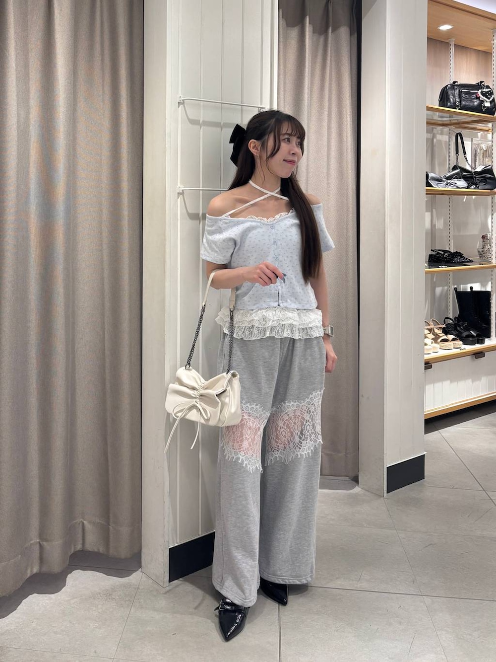 ホワイト系のショルダーバッグ、ブラック系のパンプス、ホワイト系のチューブトップを着用したレディースの夏コーディネートの2枚目の写真