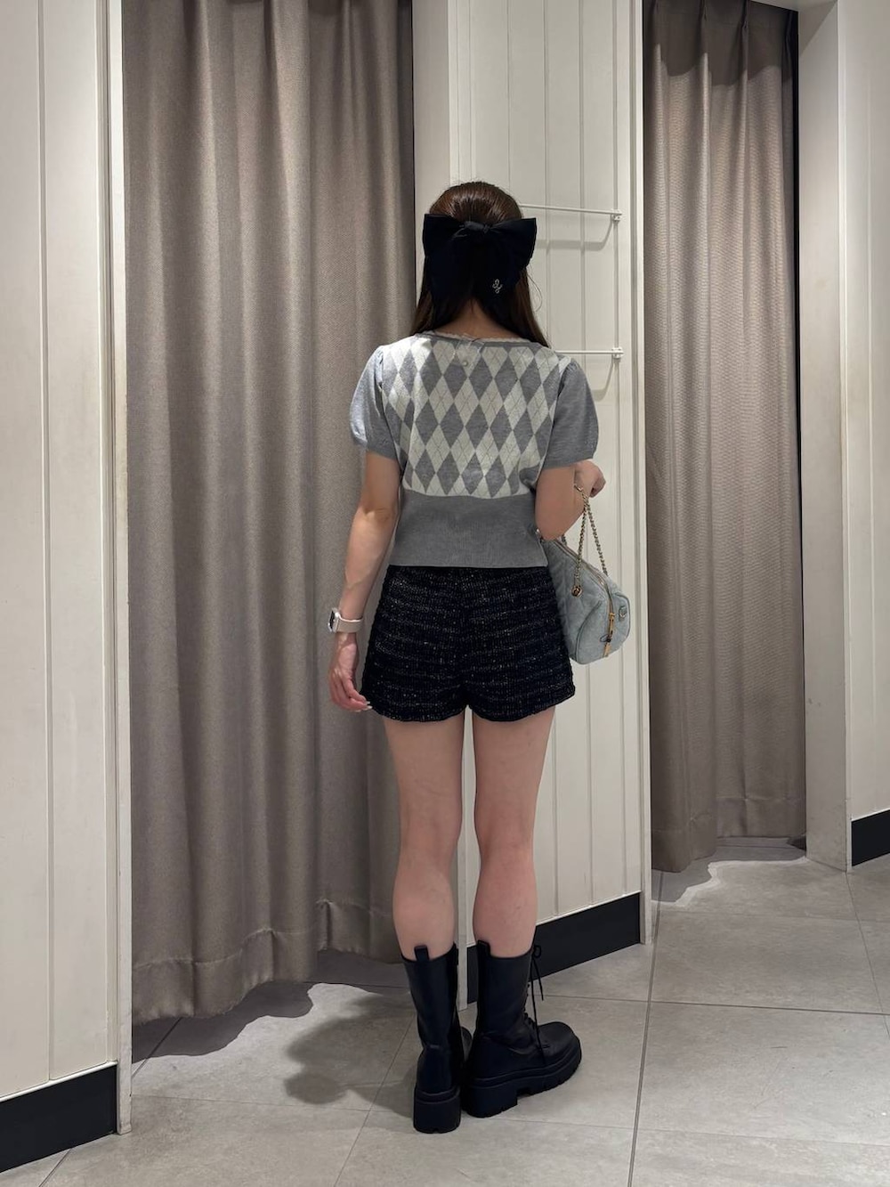 グレー系のニット/セーター、ブルー系のボストンバッグ、ブラック系のその他パンツを着用したレディースの夏コーディネートの3枚目の写真