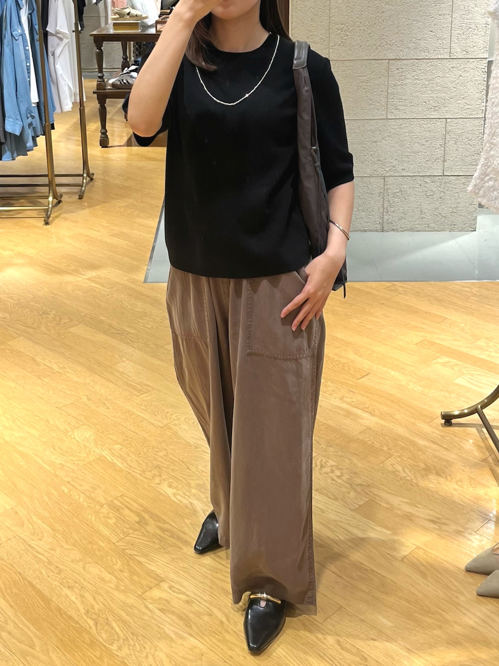 ブラック系のニット/セーター、ベージュ系のその他パンツ、ブラック系のその他シューズを着用したレディースの夏コーディネートの3枚目の写真