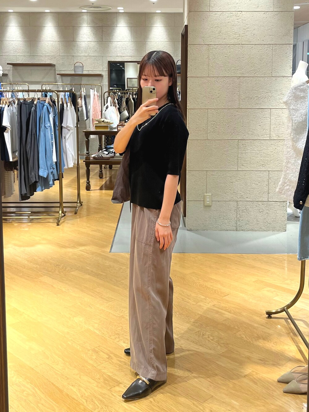 ブラック系のニット/セーター、ベージュ系のその他パンツ、ブラック系のその他シューズを着用したレディースの夏コーディネートの2枚目の写真