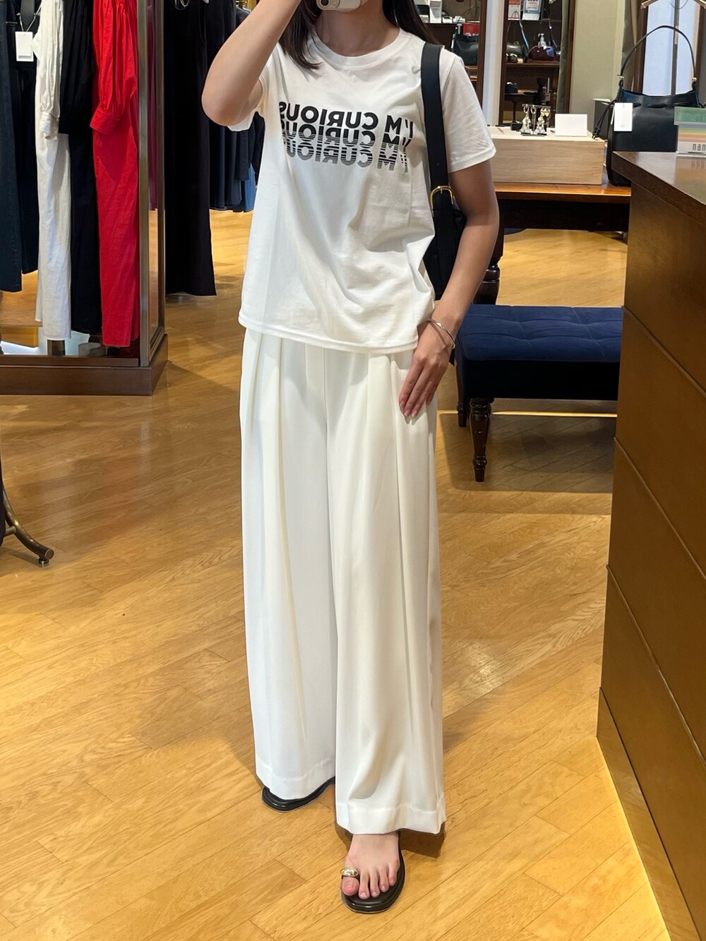 ホワイト系のTシャツ/カットソー、ホワイト系のスラックスを着用したレディースの夏コーディネートの3枚目の写真