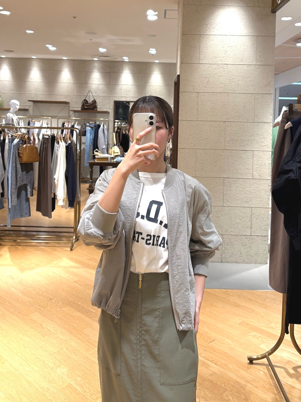 ホワイト系のTシャツ/カットソー、グリーン系のブルゾン、グリーン系のスカートを着用したレディースの春コーディネートの3枚目の写真