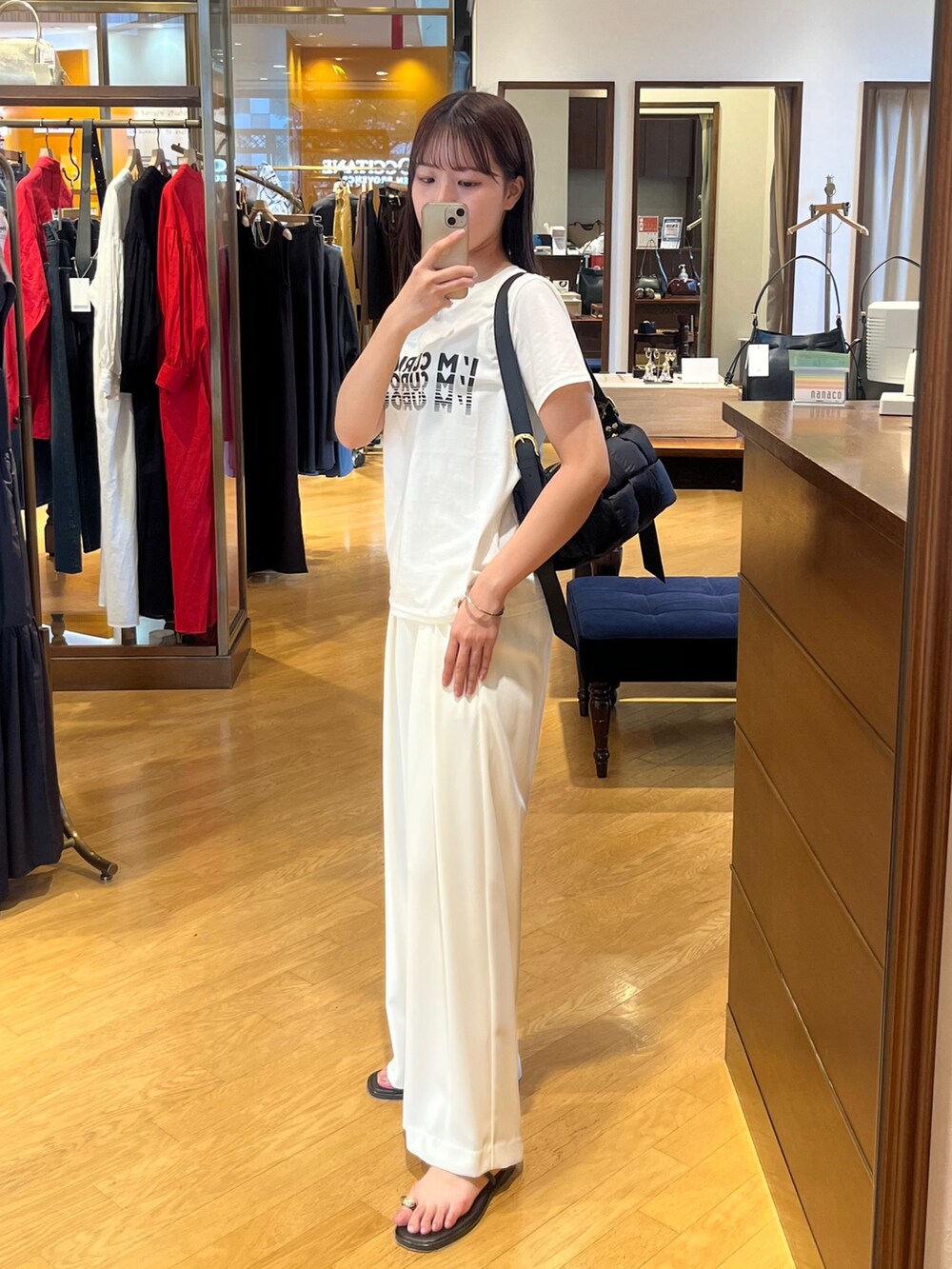 ホワイト系のTシャツ/カットソー、ホワイト系のスラックスを着用したレディースの夏コーディネートの2枚目の写真