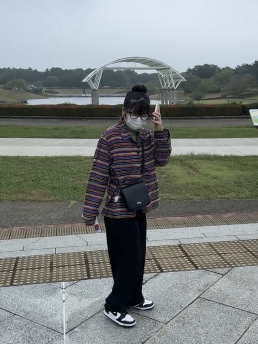 ブラック系のスラックスを着用したレディースの春コーディネートの2枚目の写真