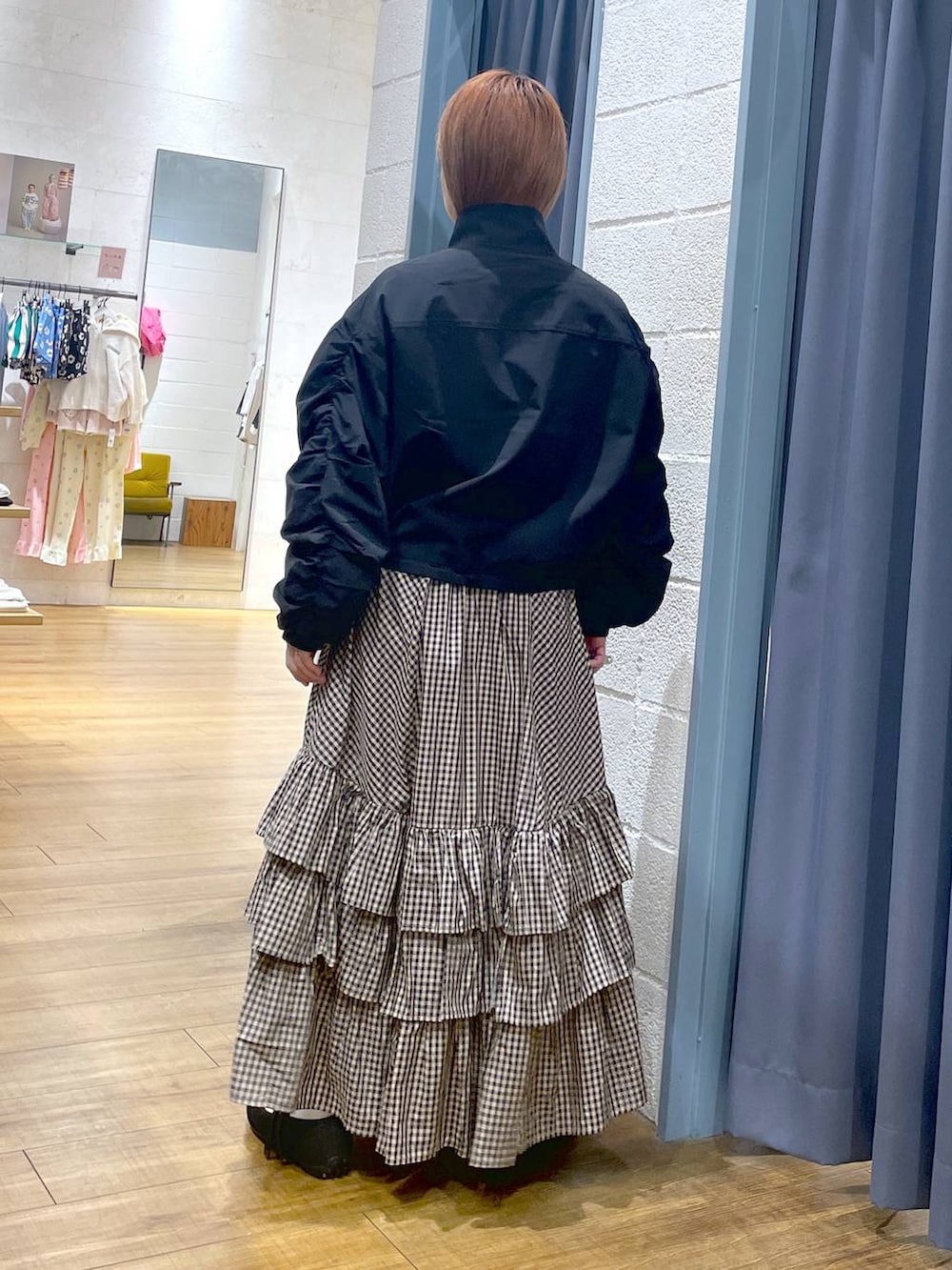 ブラック系のスニーカー、ブラック系のブルゾン、ブラウン系のスカートを着用したレディースの春コーディネートの6枚目の写真