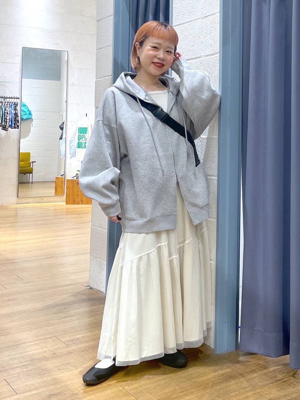 グレー系のパーカー、ブラック系のショルダーバッグ、ブラック系のスニーカーを着用したレディースの春コーディネートの4枚目の写真