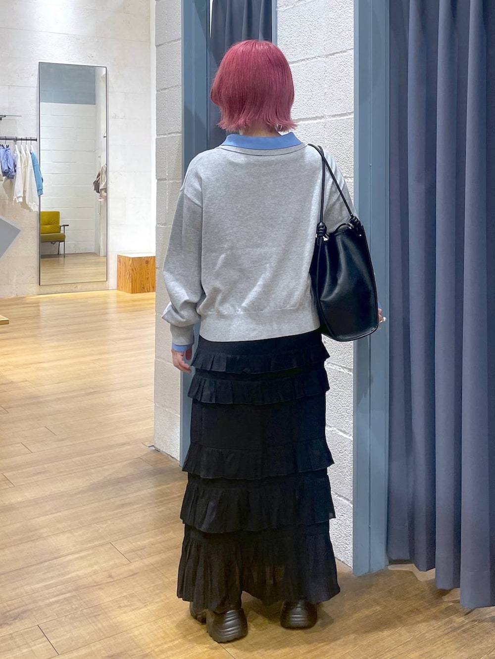 ブラック系のローファー、ブラック系のスカート、ブラック系のトートバッグを着用したレディースの春コーディネートの4枚目の写真