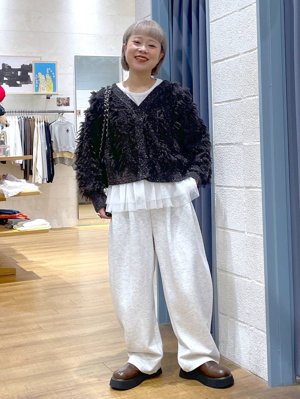 グレー系のスウェットパンツ、ブラウン系のサンダル、ブラウン系のカーディガン/ボレロを着用したレディースの秋コーディネートの2枚目の写真