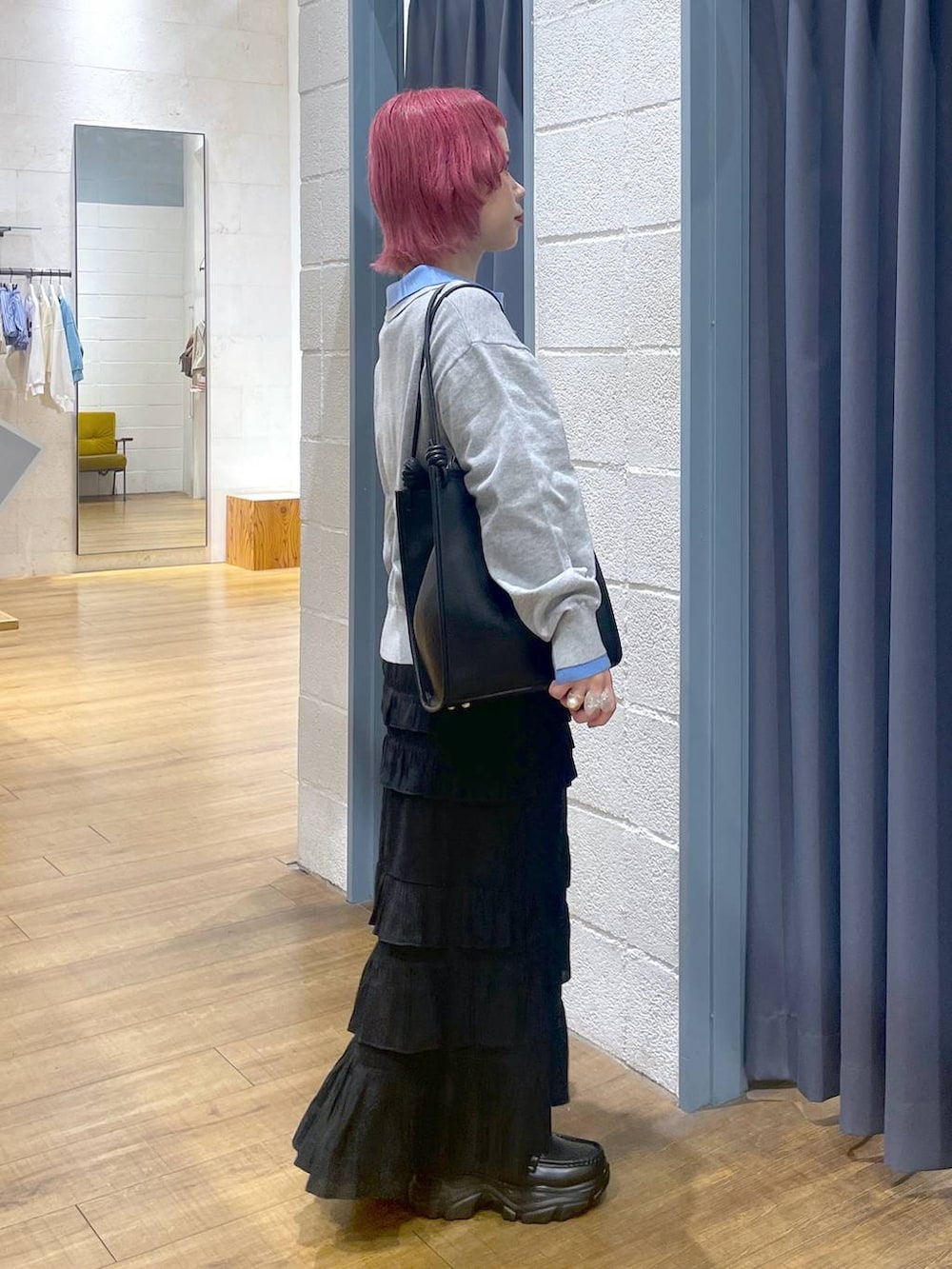 ブラック系のローファー、ブラック系のスカート、ブラック系のトートバッグを着用したレディースの春コーディネートの2枚目の写真