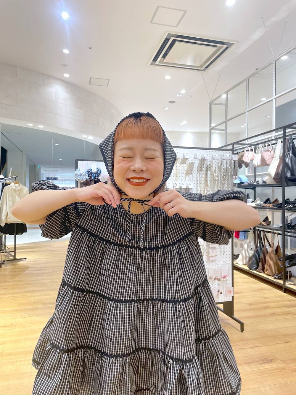 グレー系のスウェットパンツ、ホワイト系のワンピースを着用したレディースの春コーディネートの2枚目の写真