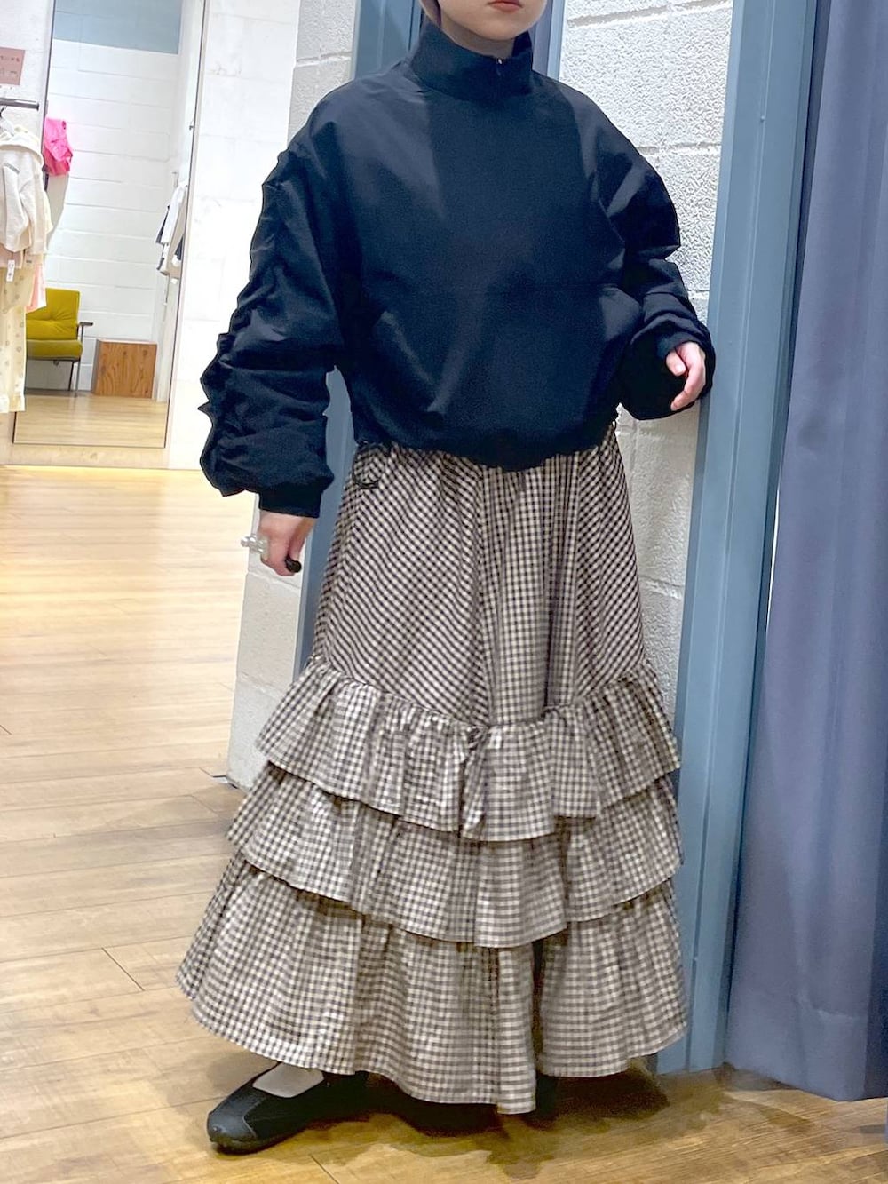 ブラック系のスニーカー、ブラック系のブルゾン、ブラウン系のスカートを着用したレディースの春コーディネートの5枚目の写真