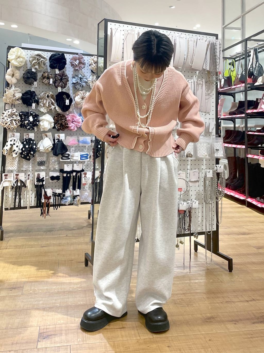 グレー系のスウェットパンツ、ピンク系のカーディガン/ボレロ、ブラック系のサンダルを着用したレディースの冬コーディネートの4枚目の写真