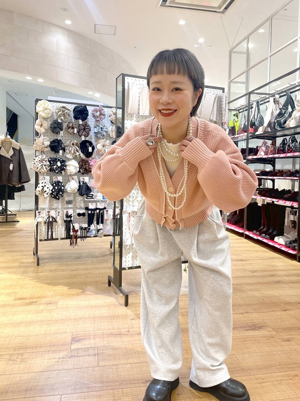 グレー系のスウェットパンツ、ピンク系のカーディガン/ボレロ、ブラック系のサンダルを着用したレディースの冬コーディネートの3枚目の写真